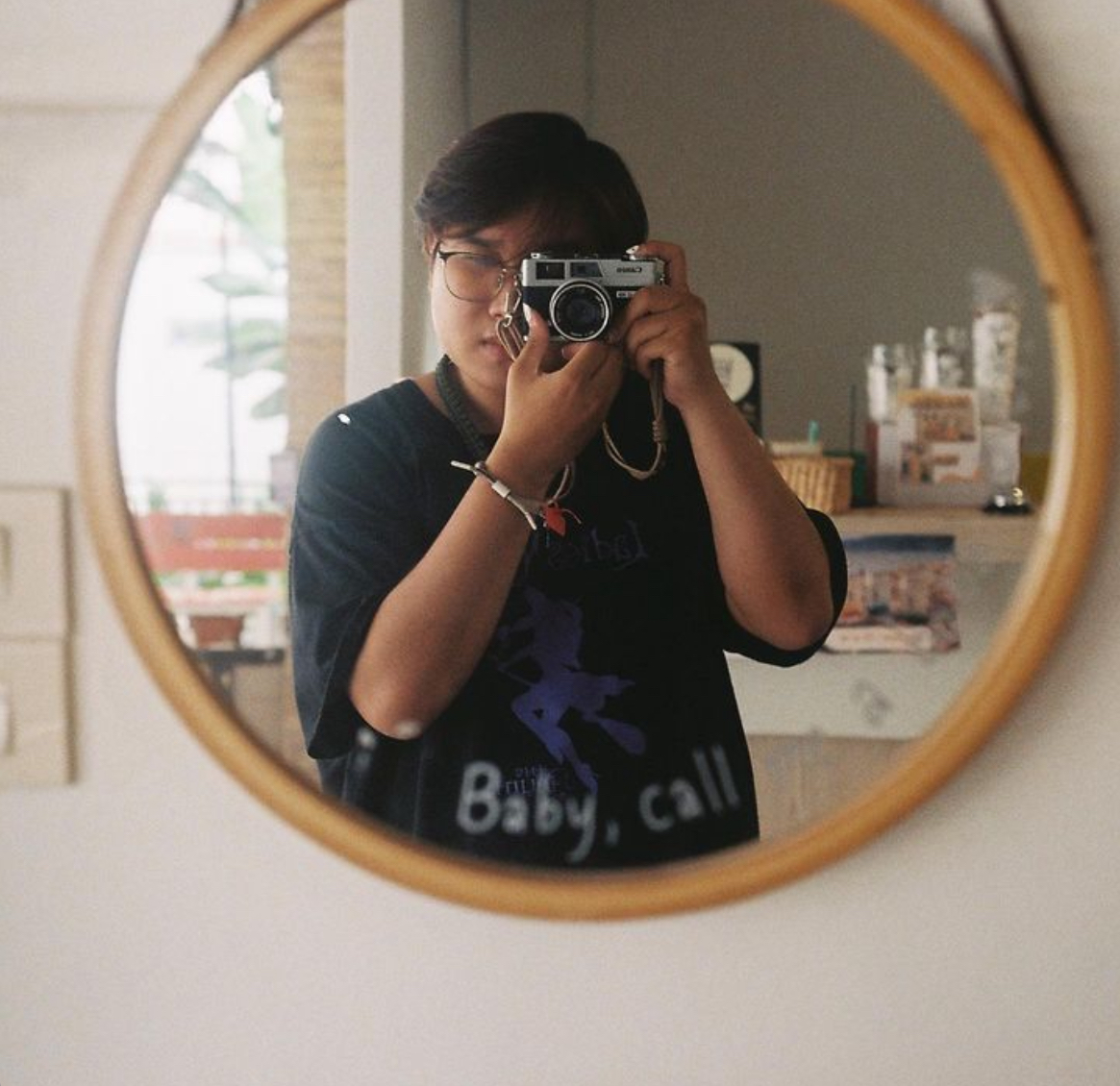 Keem taking a photo in a round mirror